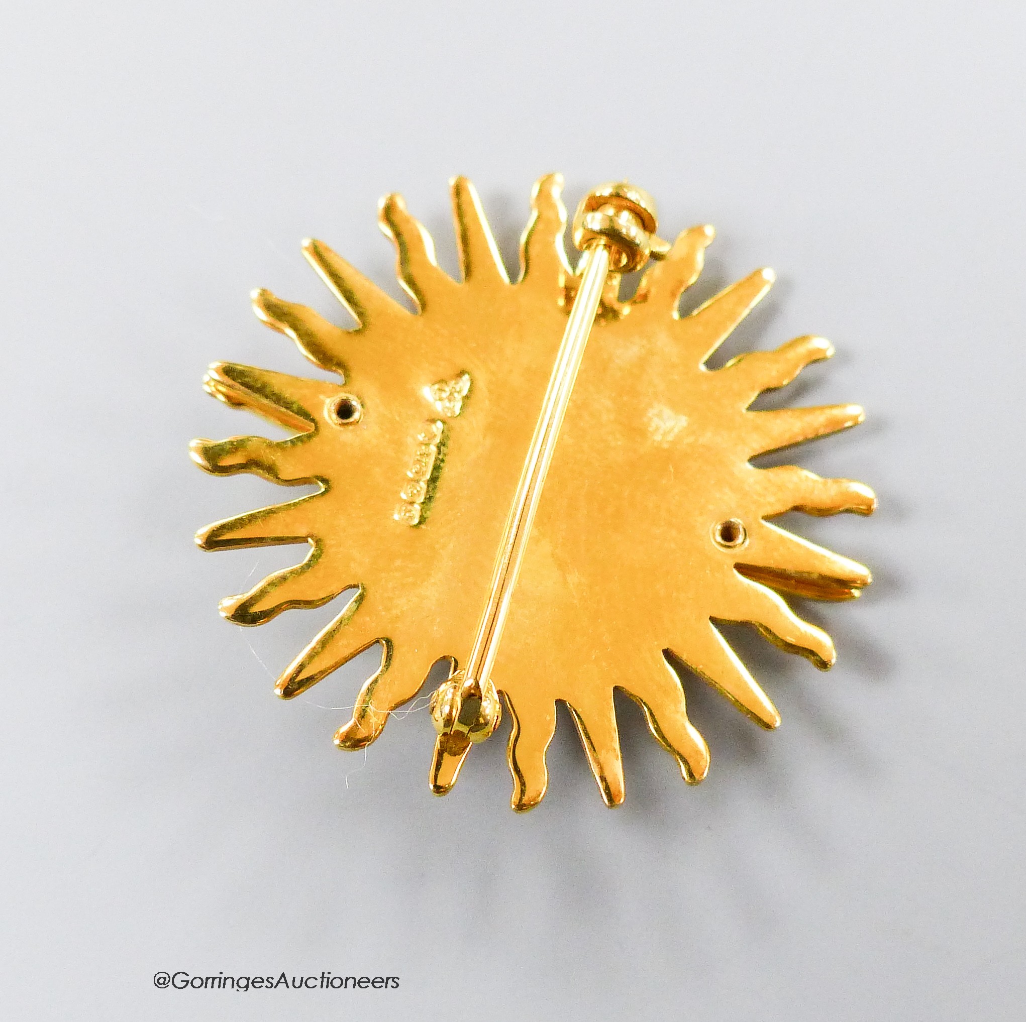 A modern 9ct gold and red enamel brooch, modelled as a sword and crown, with sun background, Garrard & Co, London, 1990, 30mm, gross weight 9 grams, with Garrards box.